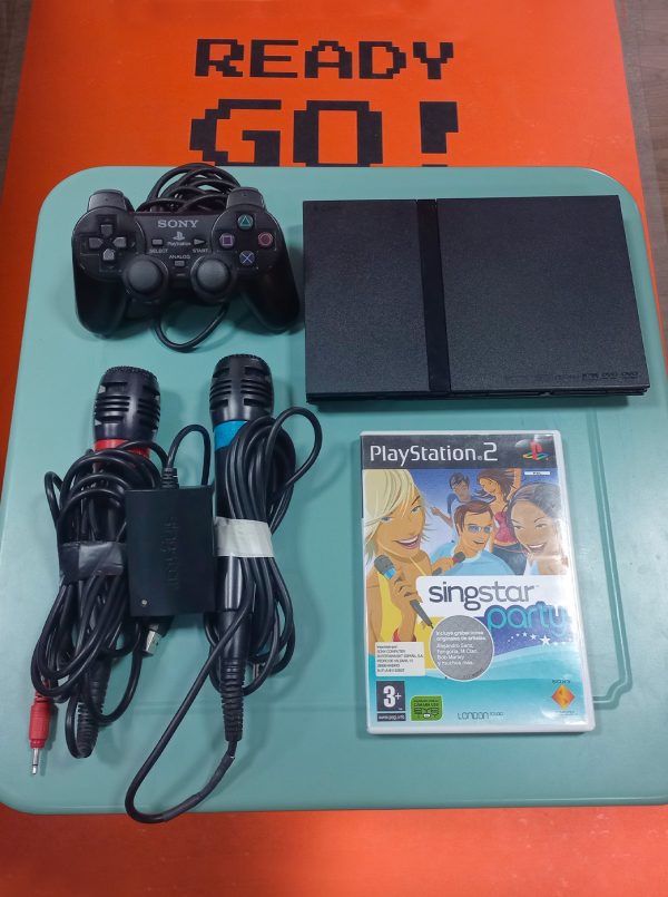 PlayStation 2 Slim con un mando, dos micrófonos y el juego de SingStar Party